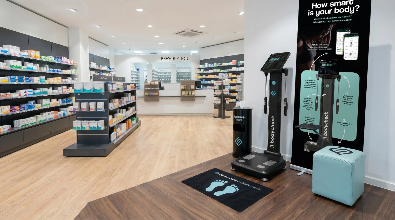 Bodycheck-Station mit fitness nation Fußmatte in heller, moderner Apotheke – sichtbar platziert zwischen Regalen und Beratungstheke